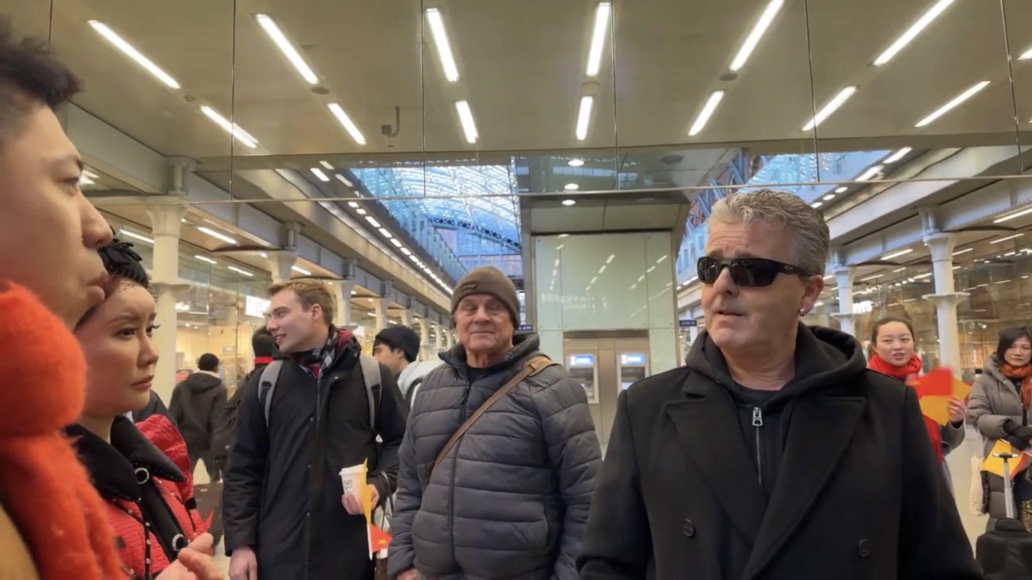 英國鋼琴家卡瓦納(Brendan Kavanagh)19日在倫敦聖潘克拉斯國際車站(St Pancras International)商場，直播鋼琴演奏，遭一群手拿五星旗的小粉紅亂入，要求卡瓦納停止直播，因為「中國法律不允許」。(X平台/@Byron_Wan)