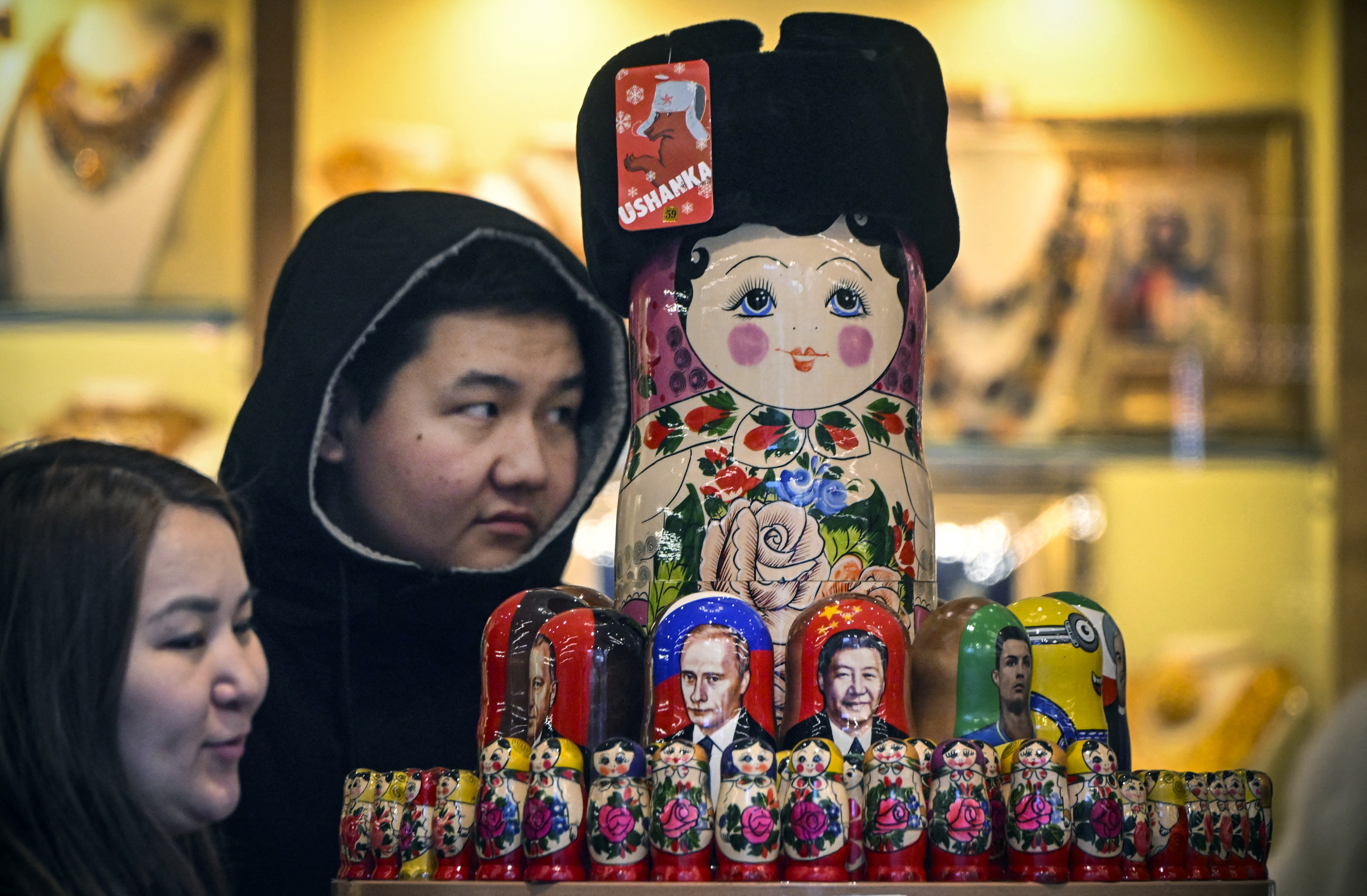 遊客在莫斯科市中心觀看印有中國國家主席習近平和俄羅斯總統蒲亭圖像的俄羅斯木製玩偶。(AFP)