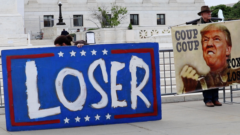 民眾在最高法院擺出看板，抗議最高法院介入川普是否有豁免權的爭議，將影響川普遭控密謀推翻2020大選結果的官司審理。(圖：中央社)