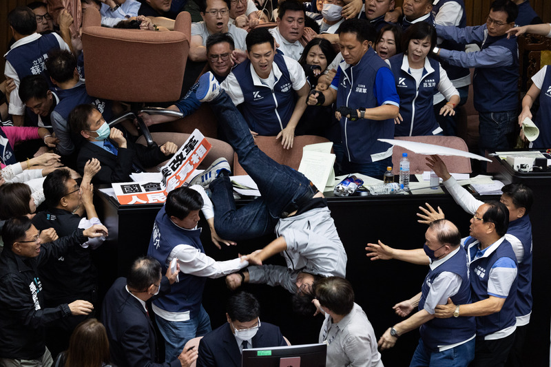 立法院會17日處理藍白所提國會改革法案，晚間進行逐條討論時，民進黨立委沈伯洋（中摔落者）等人欲搶占主席台但遭國民黨立委推落，沈伯洋以倒栽蔥方式摔下，隨後被救護車送往醫院就醫。 (圖：中央社)