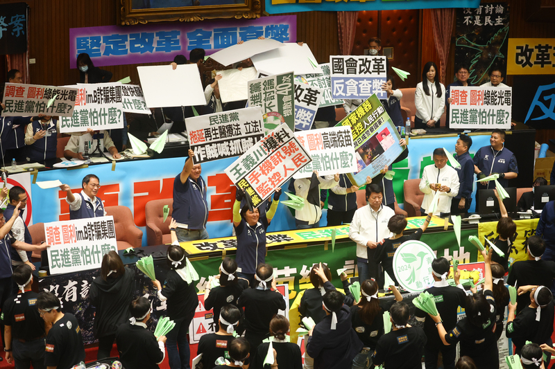 立法院會28日續審國會職權修法相關法案，下午3時許法案完成二讀，民進黨立委們朝主席台射出青色的紙飛機，希望藍白兩黨聽進場外「青鳥行動」群眾的聲音。(圖：中央社)