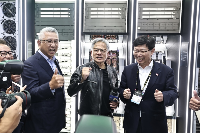 圖為輝達（NVIDIA）執行長黃仁勳（中）6月4日在2024台北國際電腦展（COMPUTEX 2024）參訪鴻佰攤位，與鴻海董事長劉揚偉（右）互動、喊話。 (圖：中央社資料照片)