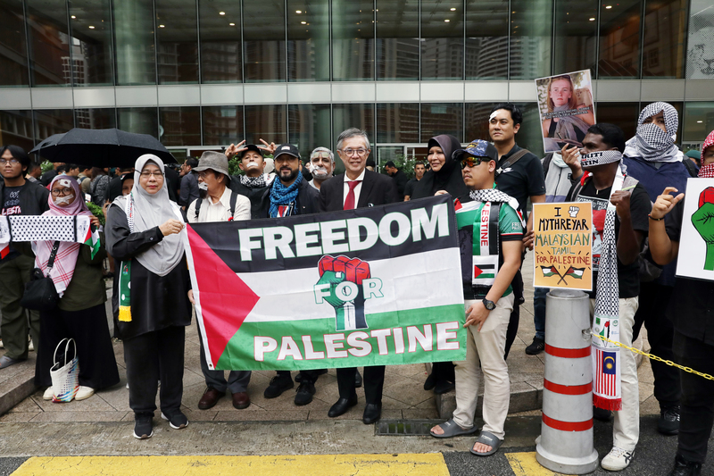 馬來西亞社運與人權運動團體10日傍晚在吉隆坡「美國獨立紀念日慶祝活動」場外集會抗議，他們穿戴阿拉伯巾，攜帶圍巾、徽章、絲帶等標語，表達聲援巴勒斯坦訴求。 (圖：中央社)