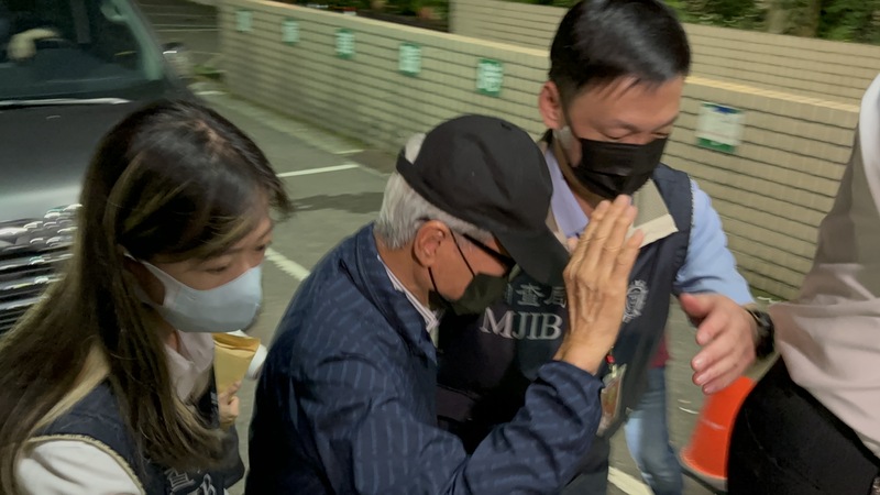 前新光人壽董事長吳東進（左2）被控營運新板傑仕堡時涉保險法特別背信罪，並在12日凌晨1時許移送新北地檢署複訊，他在人員陪同下戴帽子、墨鏡與口罩低調現身，對記者提問不發一語。 (圖：中央社)