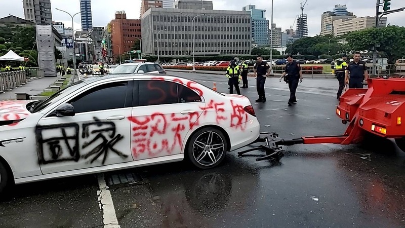杜姓男子1日下午先開著車身噴有「國家認知作戰」等字句的白色車輛到美國在台協會車道不停按喇叭，隨後又開至總統府前衝撞花台，警方已將杜男帶回派出所。（翻攝照片/中央社)