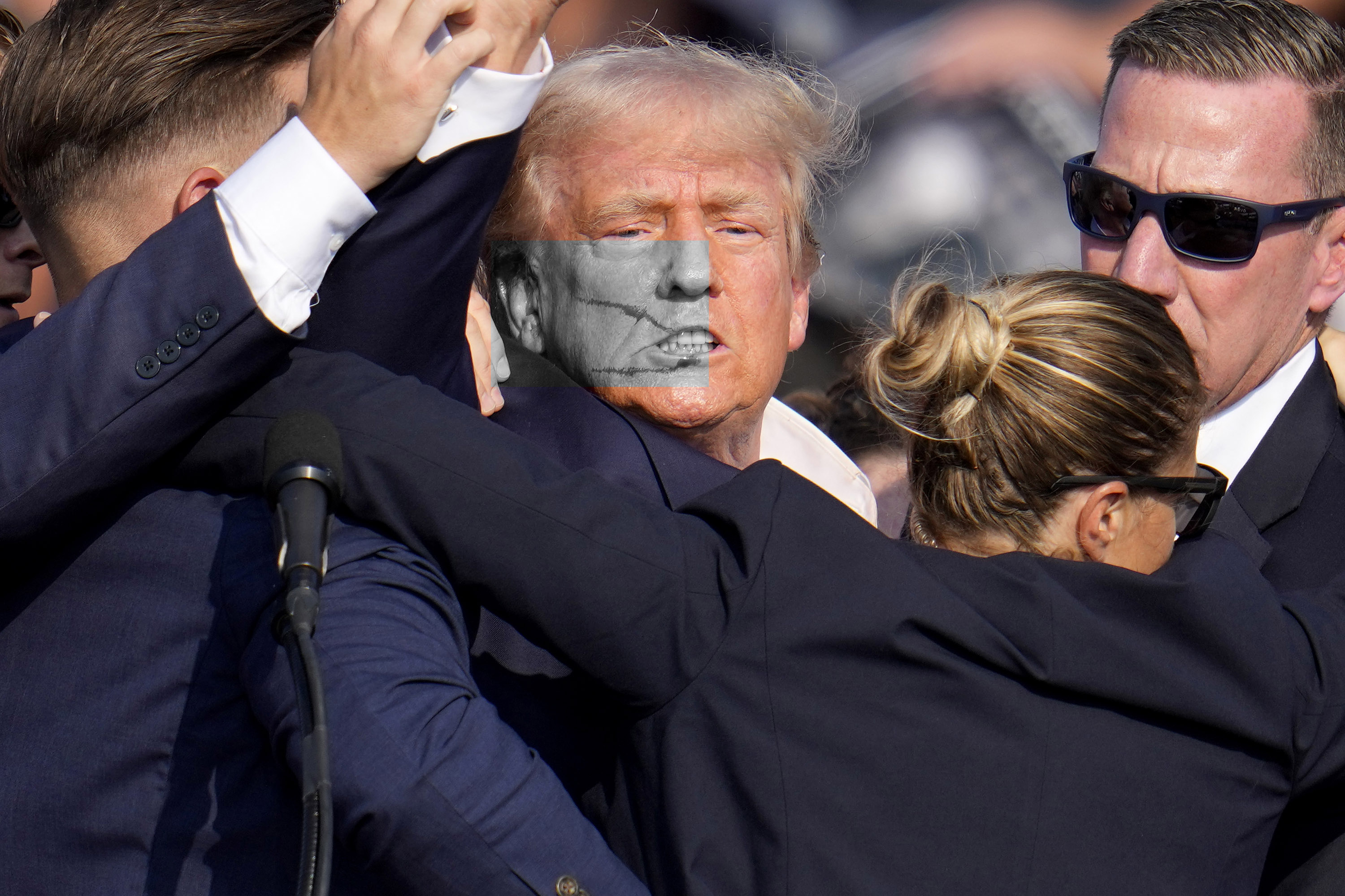 美國前總統川普(Donald Trump)13日在賓州造勢大會上遇襲濺血，隨後在安全人員護送下緊急離開。(美聯社/達志影像)
