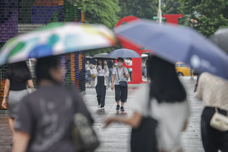 中央氣象署指出，今天(4日)鋒面快速通過，天氣不穩定，台灣北部、東半部地區、恆春半島及馬祖有局部短暫陣雨。圖為台北市信義區民眾雨中撐傘。 (圖：中央社)