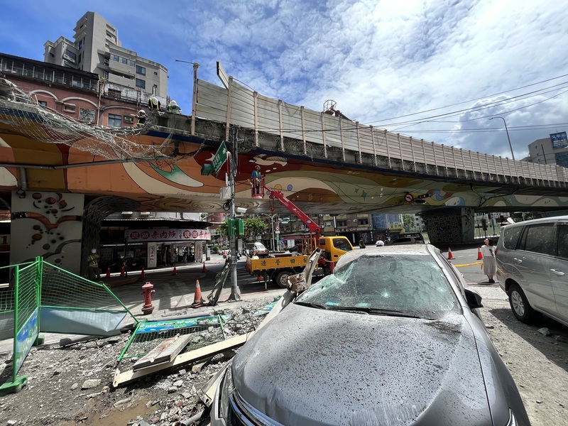 新北市三重區台1線中山高架道路往忠孝橋方向20日清晨發生聯結車載送鋼梁翻覆事故，護欄遭砸毀，波及橋下車輛，所幸無人傷亡。 (圖：中央社)