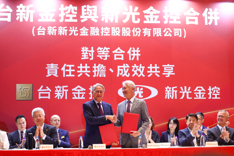 新光金與台新金22日宣布通過換股合併案，讓睽違22年的新新併再度啟動，台新金控董事長吳東亮（前左2）晚間與新光金控董事長魏寶生（前左3）完成換約儀式，握手致意。(圖：中央社)