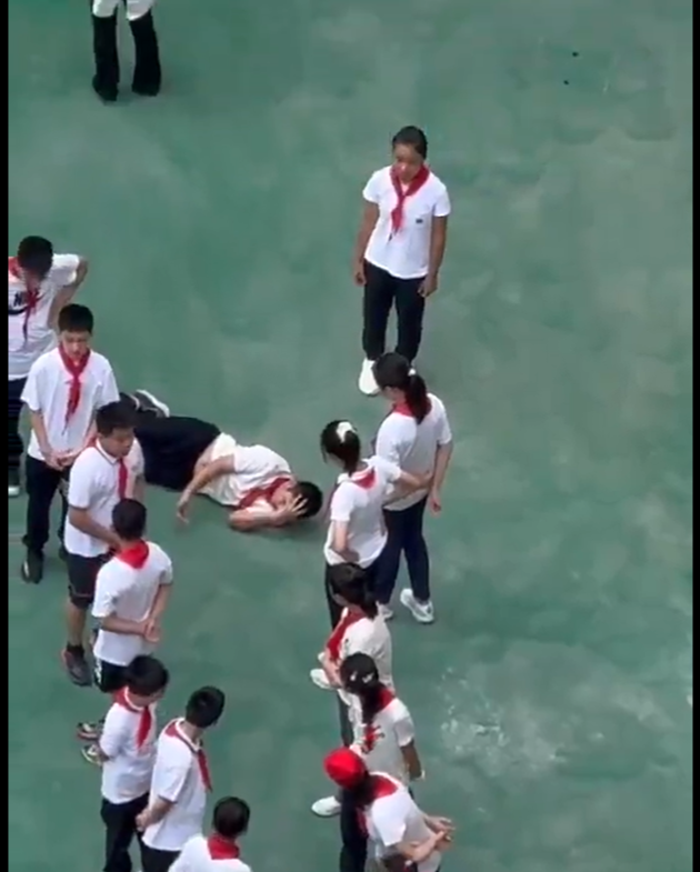 上海學生中暑倒地無人問，引發大陸網友怒批教育生病了。(影片截圖)