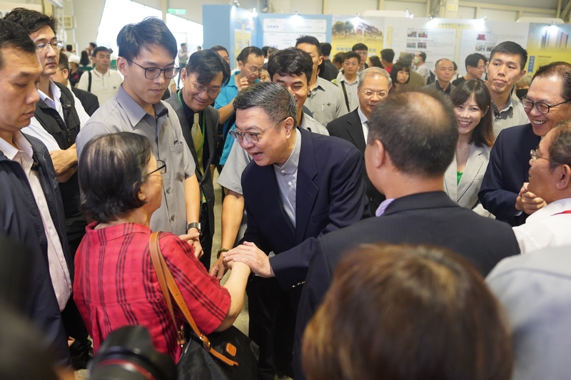 行政院長卓榮泰（中）21日在台北出席第6屆危老都更博覽會，遇到有都更需求的民眾上前表達意見。(圖：中央社)
