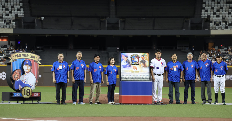 中職統一獅隊投手潘威倫(白衣)28日晚間在台北大巨蛋引退賽後進行感謝儀式，主軸圍繞過往國家隊榮光，特別邀請帶過潘威倫的國家隊總教練，包括林華韋(左起)、楊賢銘、陳進財、徐生明遺孀謝榮瑤、洪一中(右起)、謝長亨、郭泰源與葉志仙等人到場見證。(圖：中央社)