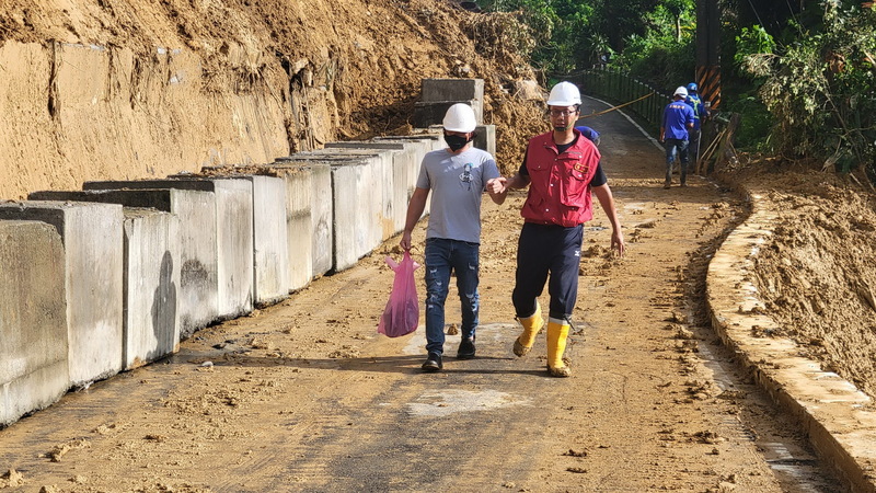 新北市瑞芳區「阿美家園」連外道路一度因邊坡土石坍方中斷，5日雨勢緩和、邊坡狀況穩定，區公所成功搶通，已可供居民進出，不過尚有部分路面殘留泥濘與碎石等，需要沖洗清潔以確保安全。（瑞芳區公所提供） (圖：中央社)