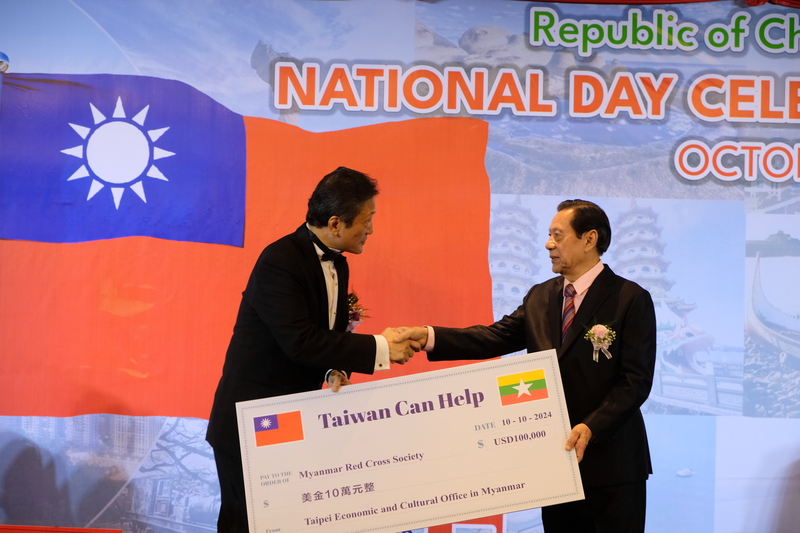 駐緬甸代表周中興（左）5日在中華民國113年國慶酒會中，代表外交部捐贈10萬美元賑災，由緬甸紅十字會代表接受。 (圖：中央社)