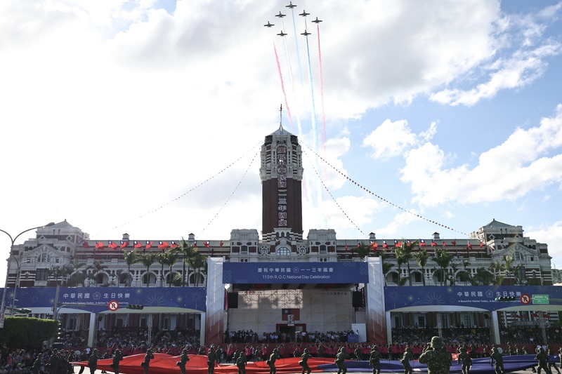 圖為6日國慶預演，空軍雷虎小組7架AT3教練機編成五角隊形，施放紅藍白3色彩煙低空通過總統府上方，為預演劃下完美句點。(圖：中央社)
