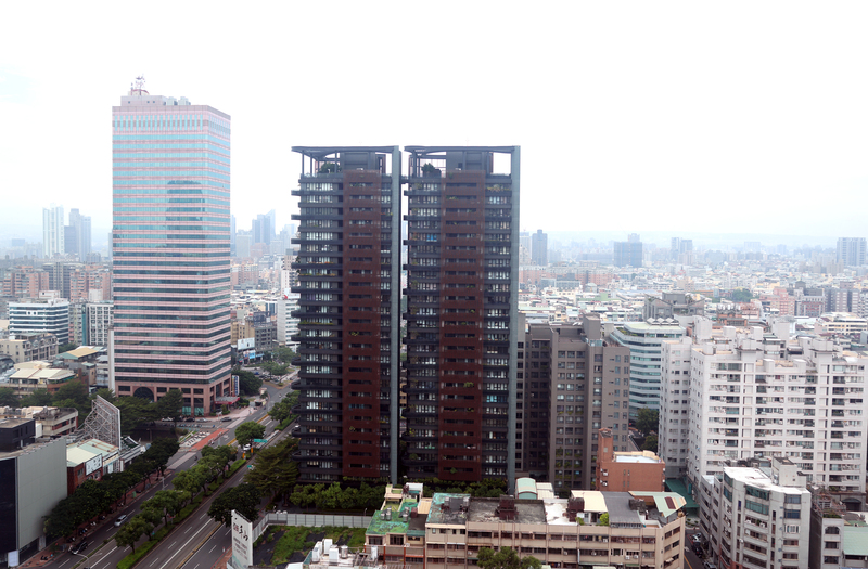 大型行庫的不動產放款總量因受法規限制，減少對民眾的購屋放款或延緩核貸，導致房地合一稅減少與土增稅成長減緩。圖為台中市西區街頭建築大樓。 (資料照片：中央社)