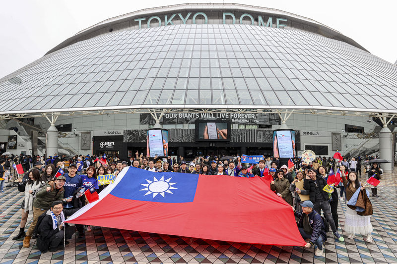 世界12強棒球賽4強複賽台灣隊21日首戰對上委內瑞拉，賽前球迷齊聚東京巨蛋外拉開巨幅國旗，一同為台灣隊加油打氣。 (圖：中央社)