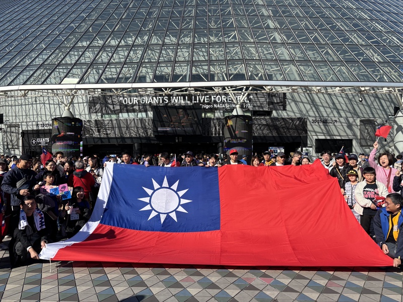 世界12強棒球賽台灣隊進入複賽，第2場22日在東京巨蛋對決美國隊，東京是大晴天，台灣球迷比天氣更加熱情，人數也比昨天更多，球迷特製巨幅國旗，應援台灣隊。中央社記者戴雅真東京攝  113年11月22日 (圖：中央社)