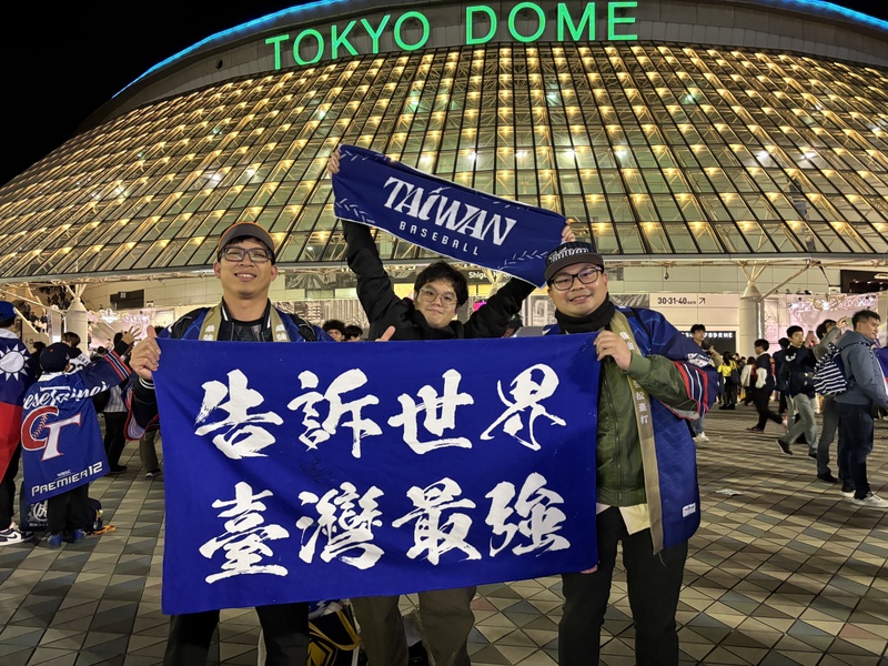 世界12強棒球賽複賽最後一天上演台日大戰，球迷在東京巨蛋前拿著「告訴世界，台灣最強」的旗幟。(圖：中央社)