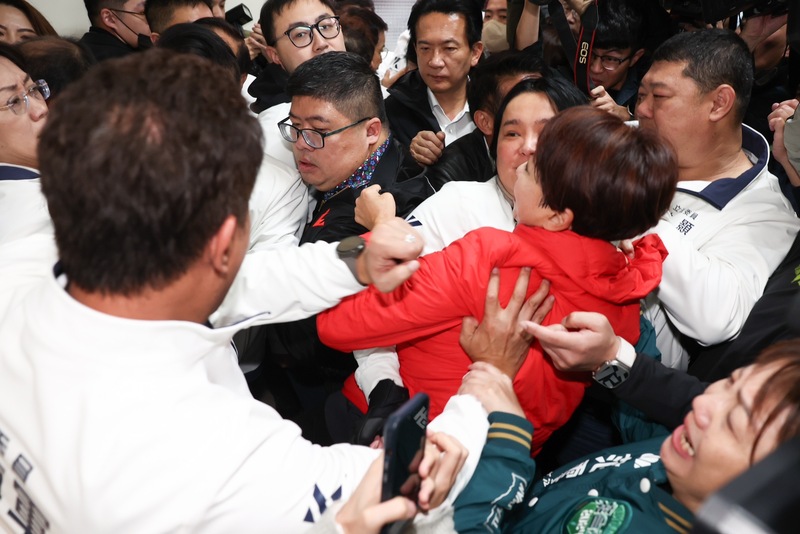 立法院內政委員會16日再度排審攸關調整罷免門檻的選罷法修正草案，為阻擋民進黨立委進入會議室，國民黨立委游顥、陳玉珍與民進黨立委陳亭妃、蔡易餘等人在會議室外走廊爆發數波推擠衝突。 (圖：中央社)