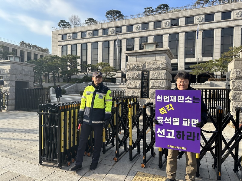 韓國憲法法院16日上午10時召開大法官會議，一早在憲法法院前已經開始有民眾手持標語，要求憲法法院「立即宣判罷免總統尹錫悅」。(圖：中央社)