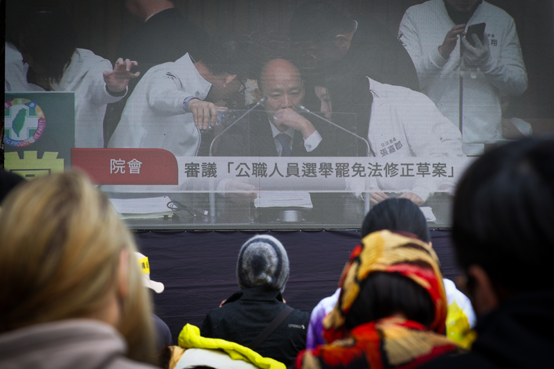 立法院會20日處理選罷法等修正草案，公民團體在院外發起活動、訴求退回法案，下午與會群眾持續透過大螢幕關注議場內審議進度。(圖：中央社)