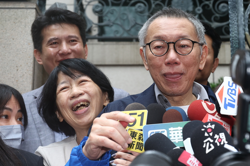 民眾黨主席柯文哲（前右）27日交保返家，在家門前發表簡短談話，妻子陳佩琪（前中）也露出笑容。 (圖：中央社)