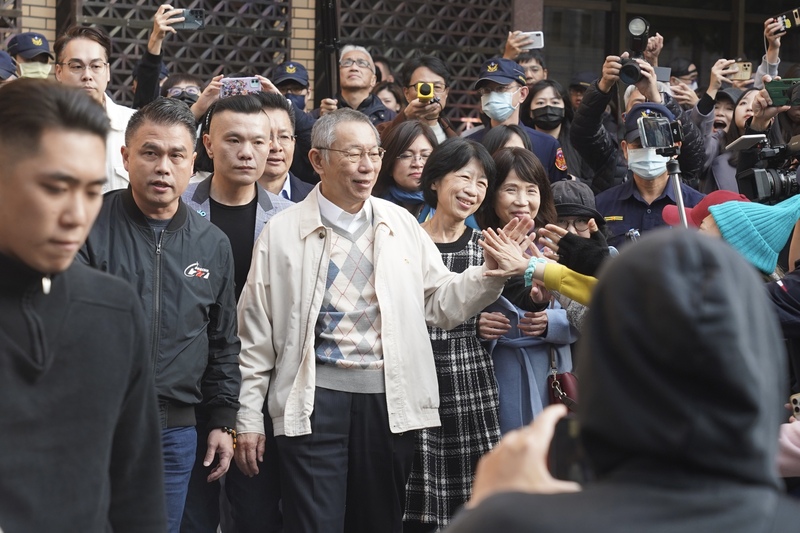 北院29日裁定前台北市長柯文哲(中白外套者)以新台幣7000萬元交保、須電子監控。柯文哲妻子陳佩琪(格紋洋裝者)30日完成具保手續後，下午在民眾黨員陪同下步出法院，並與一旁守候的支持者擊掌致意。(圖：中央社)