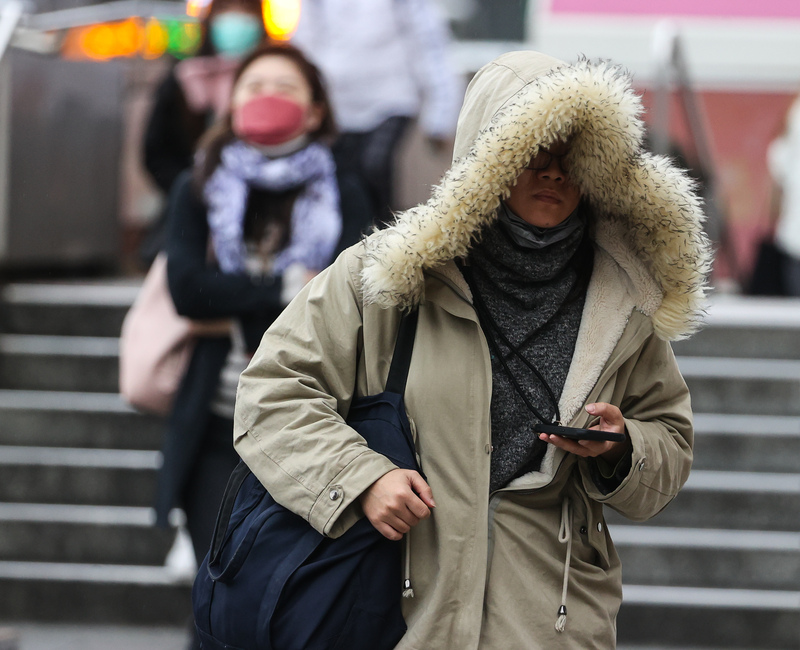 圖為民眾穿上厚外套、戴帽子禦寒。資料照。(圖：中央社)