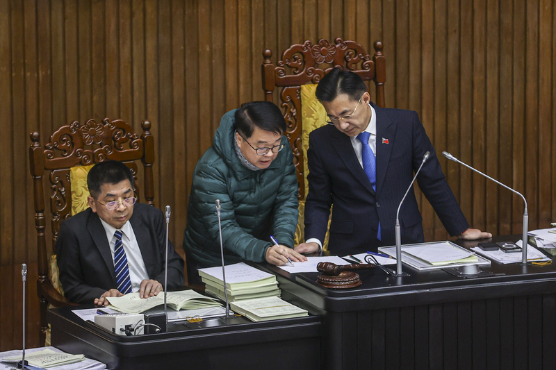 立法院會21日凌晨繼續討論114年度中央政府總預算案，民進黨立委吳秉叡（中綠衣）一度提出異議，與副院長江啟臣（右）在主席台討論、交換意見。(圖：中央社)