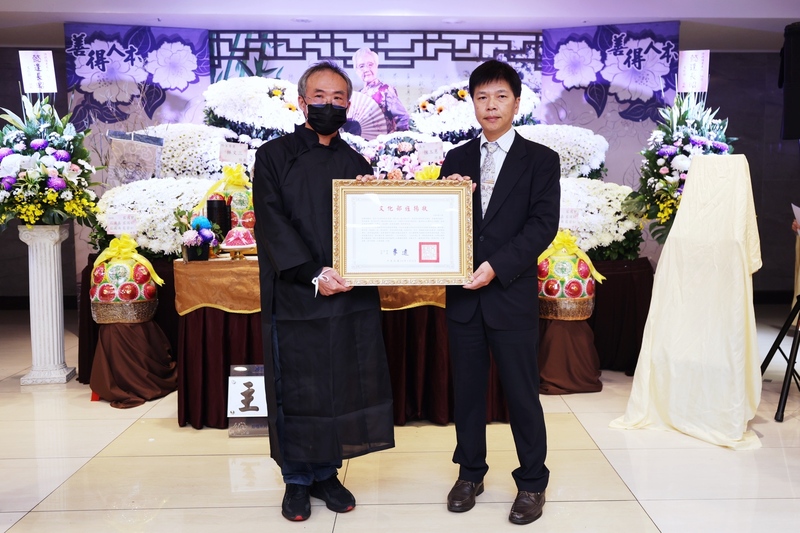 台北市傳統表演藝術歌仔戲保存者陳剩辭世，文化部主任秘書林宏義(右)25日出席告別式並頒贈文化部旌揚狀，由陳剩兒子許坤生(左)代表受贈。(文化部提供) (圖：中央社)