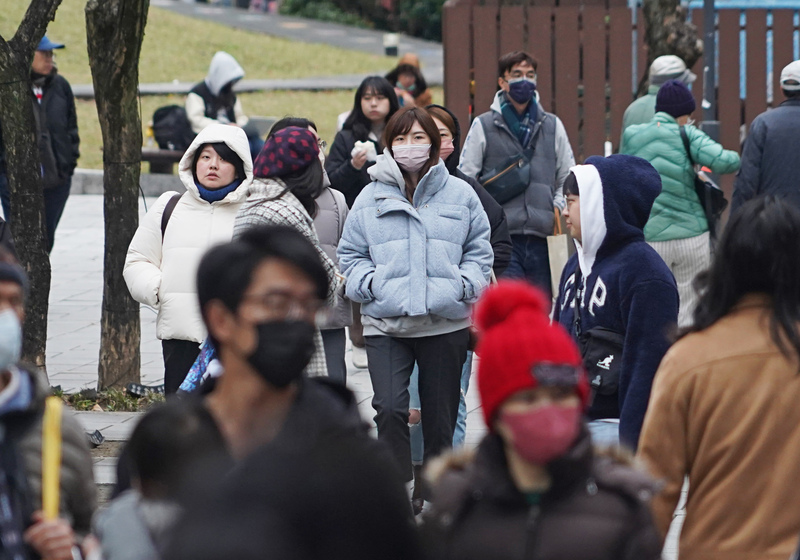 圖為民眾穿外套、戴帽子禦寒。資料照。(圖：中央社)