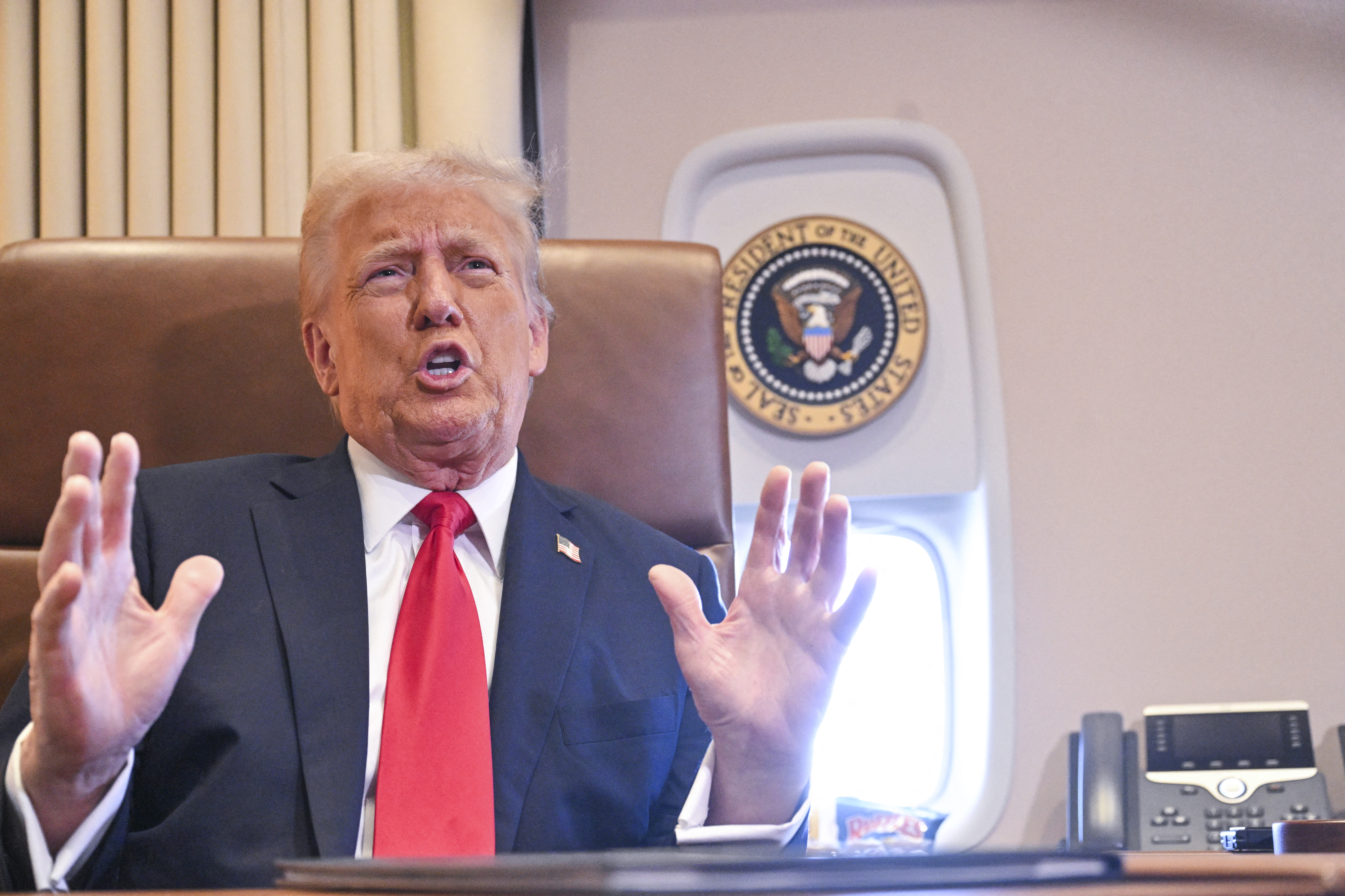 美國總統川普(Donald Trump)在空軍一號(Air Force One)上向媒體發表談話。(AFP)