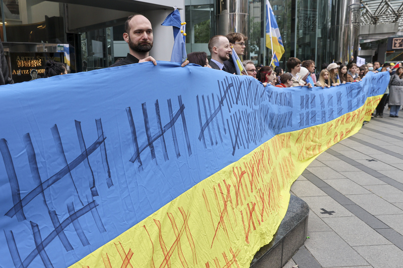 面對強權，烏克蘭與香港人同樣用血與淚爭取自己的未來。圖為俄烏戰爭屆滿3週年前夕，多位在台烏克蘭人與外籍人士齊聚在莫斯科駐台北代表處前展開巨幅烏克蘭國旗。 (資料照片：中央社)