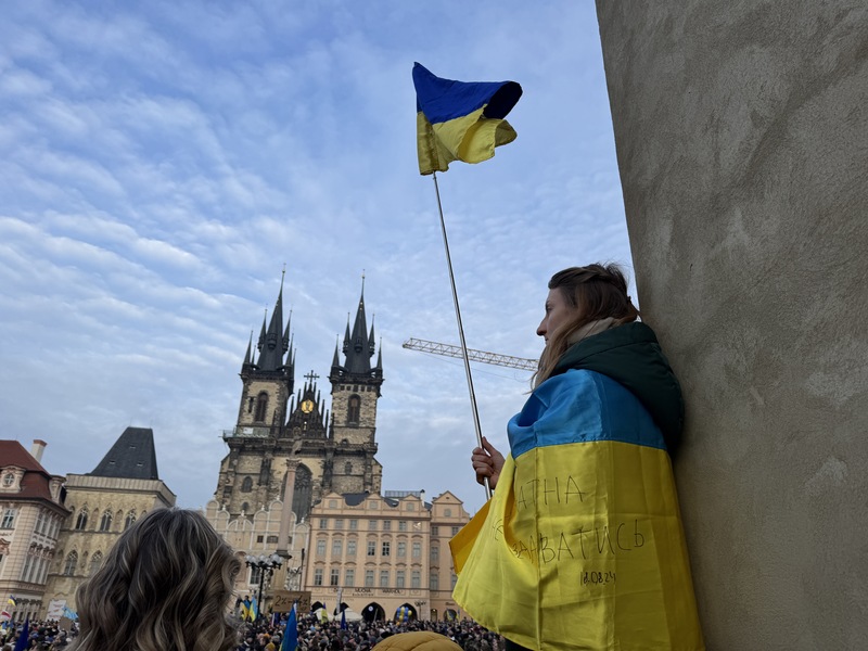 俄烏戰爭3週年，數千人23日齊聚布拉格舊城廣場聲援烏克蘭，現場有參與者手持烏克蘭國旗，身上也披著烏克蘭國旗。 (圖：中央社)