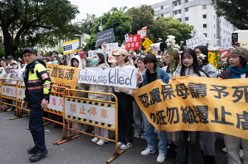 劉姓保母姊妹涉虐童致死案，台北地方法院第4次開庭審理，不少民眾19日下午在法院外集結，手持標語及白花並高喊「唯一死刑」。(圖：中央社)