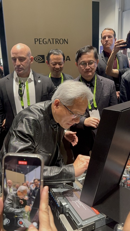 黃仁勳20日造訪輝達GTC大會和碩展位，和碩董事長童子賢（右後）親迎，黃仁勳在機櫃上簽名。（和碩提供） (圖：中央社)