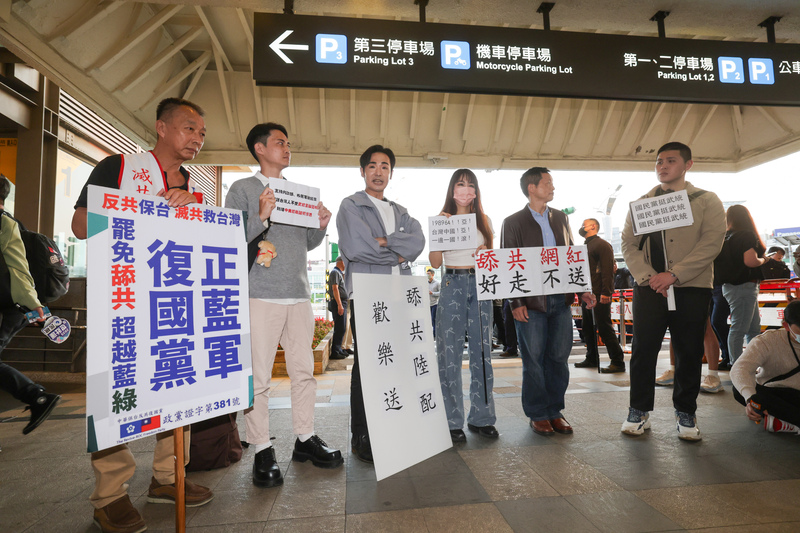 陸配劉振亞涉武統言論遭處分限期自行離境，25日將從松山機場搭晚上班機離境，網紅八炯（前左3）及「閩南狼」陳柏源（前右）等人傍晚到松山機場舉牌抗議。中央社記者裴禛攝 114年3月25日 (圖：中央社)