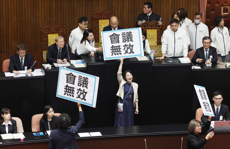 立法院會25日晚間表決通過國民黨團所提的反廢死、反戒嚴公投案逕付二讀，立法院長韓國瑜宣布時，民進黨立法院黨團幹事長吳思瑤高舉「會議無效」的板子。 (圖：中央社)