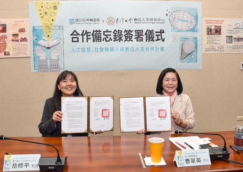 國立台灣圖書館長曹翠英（右）、台灣大學大數位人文研究中心主任岳修平（左）代表雙方簽署合作備忘錄，將以AI人工智慧與機器人實驗高齡友善的服務。（國台圖提供/中央社)
