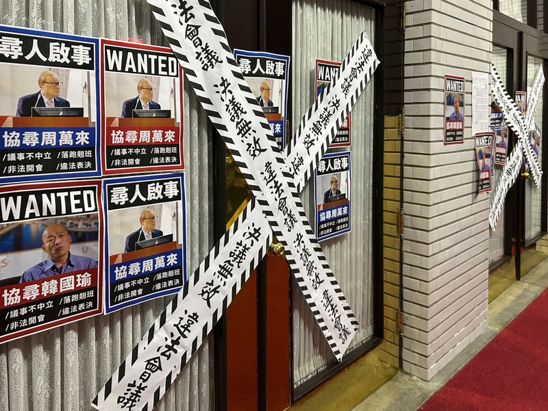 民進黨立法院黨團成員27日傍晚兵分4路，將立法院議場4個出入口貼上「違法會議、決議無效」封條，表達訴求。(圖：中央社)