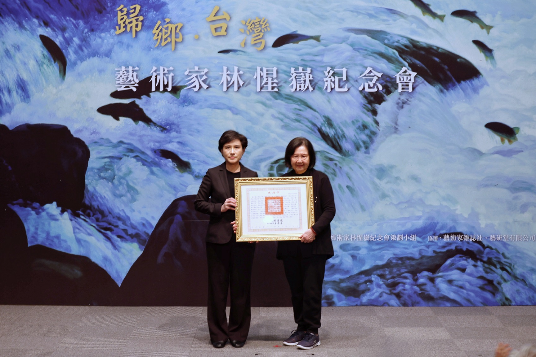 行政院副院長鄭麗君(左)代表頒贈總統褒揚令，由林惺嶽夫人魏錦秀(右)代表受贈。(文化部提供)