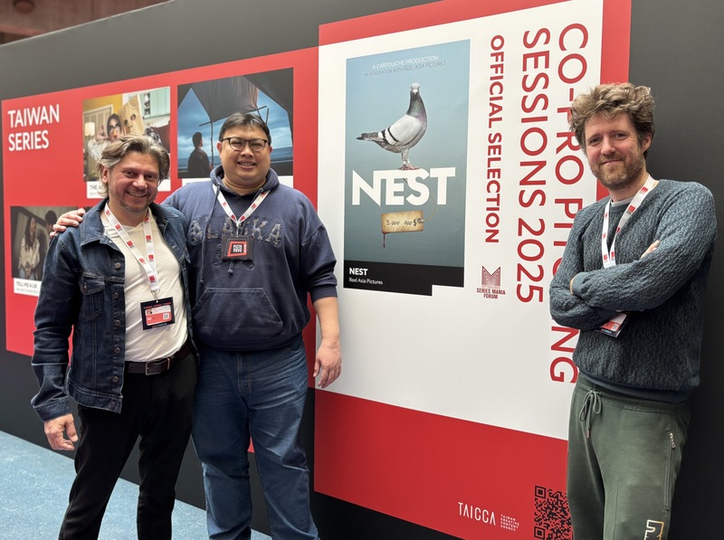 台灣、比利時合製影集案「賽鴿追殺令」（NEST）26日於法國里爾劇集展Series Mania上接受中央社訪問，談及創作源起與兩邊文化碰撞。導演兼編劇范桑德（左）、製作人魏蒙德（右）和許家豪（中）於企劃案海報前合影。 (圖：中央社)