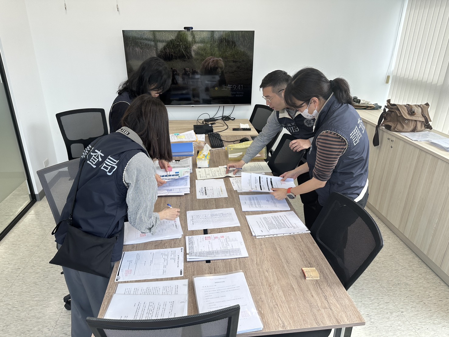 法務部調查局同步偵辦11家中企來台非法從事挖角我高科技人才案件，調查人員前往搜索。(調查局提供)