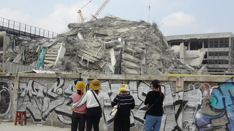 緬甸發生芮氏規模8.2強震，曼谷受到波及一棟興建中的大樓倒塌。受困工人的親友站在工地外望著倒塌建築物。(圖：中央社)