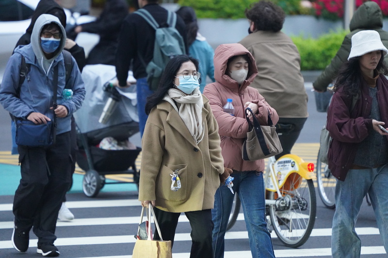 中央氣象署預報，北部週末溼冷，下雨時間長。圖為台北市大同區街頭民眾穿著厚重衣物禦寒。 (中央社資料照片)