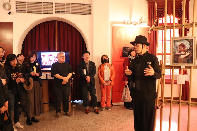 第2屆香港人權作品展持續在228國家紀念館舉行，策展人黃國才（右）導覽作品。(圖：中央社)