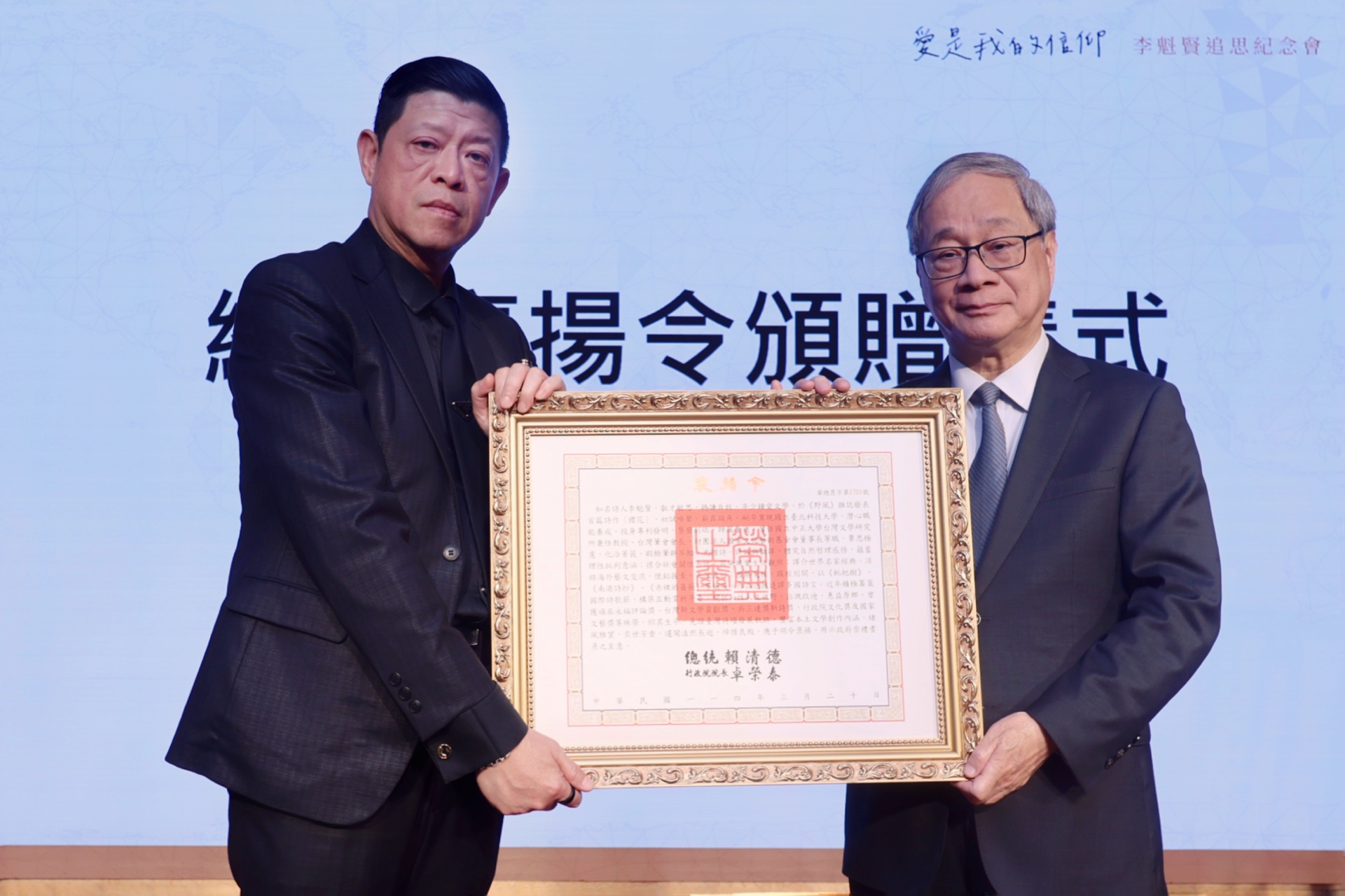 文化部長李遠(右)6日出席「愛是我的信仰－李魁賢追思紀念會」，並代表頒贈總統褒揚令，由其兒子李斯棐(左)代表受贈。(文化部提供)