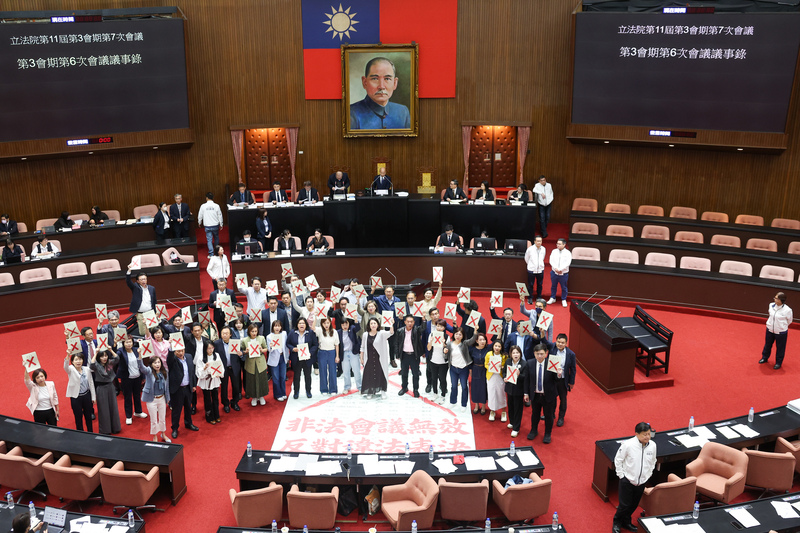 民進黨立法院黨團抗議3月25日晚上7時後進行的立法院會無效，11日國是論壇後在議場內高舉打紅色叉叉的議事錄，高喊「非法會議無效 反對違法表決」表達訴求。 (圖：中央社)