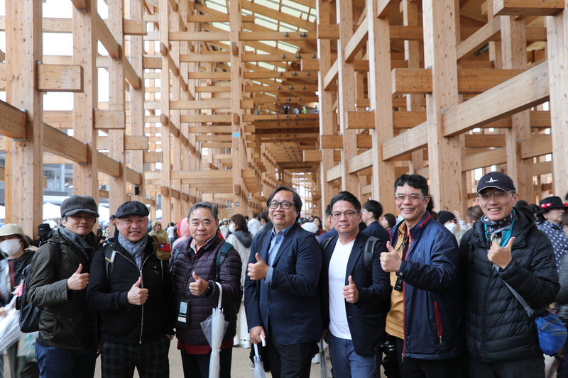 大阪世博13日正式開幕，許多台灣遊客搶在第一天體驗，建築師謝宗哲（右4）、結構技師陳冠帆（右3）等數十人就組團到世博觀看獲得金氏世界紀錄認證為全球最大木造建築的大屋頂環。 (圖：中央社)